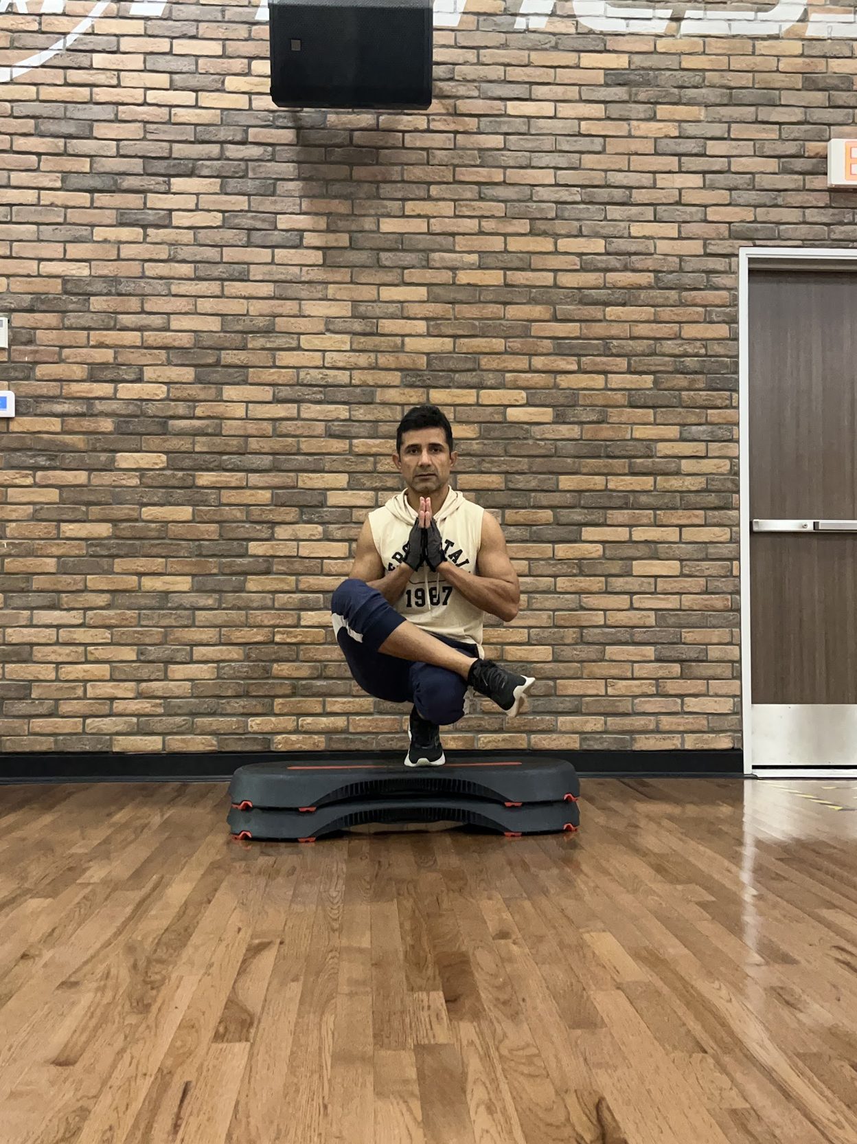 Coach Manjeet holding a pistol squat on a step platform